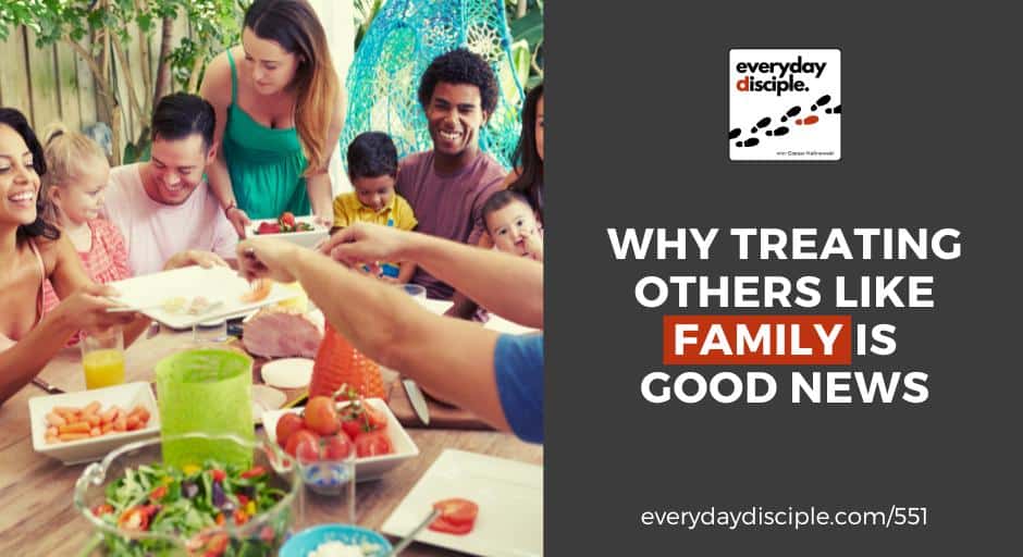 A diverse and joyful group of adults and children share a meal around a table outdoors like a family.