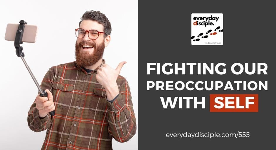 A man holding a selfie stick with a cellphone attached, having awareness and sense of self